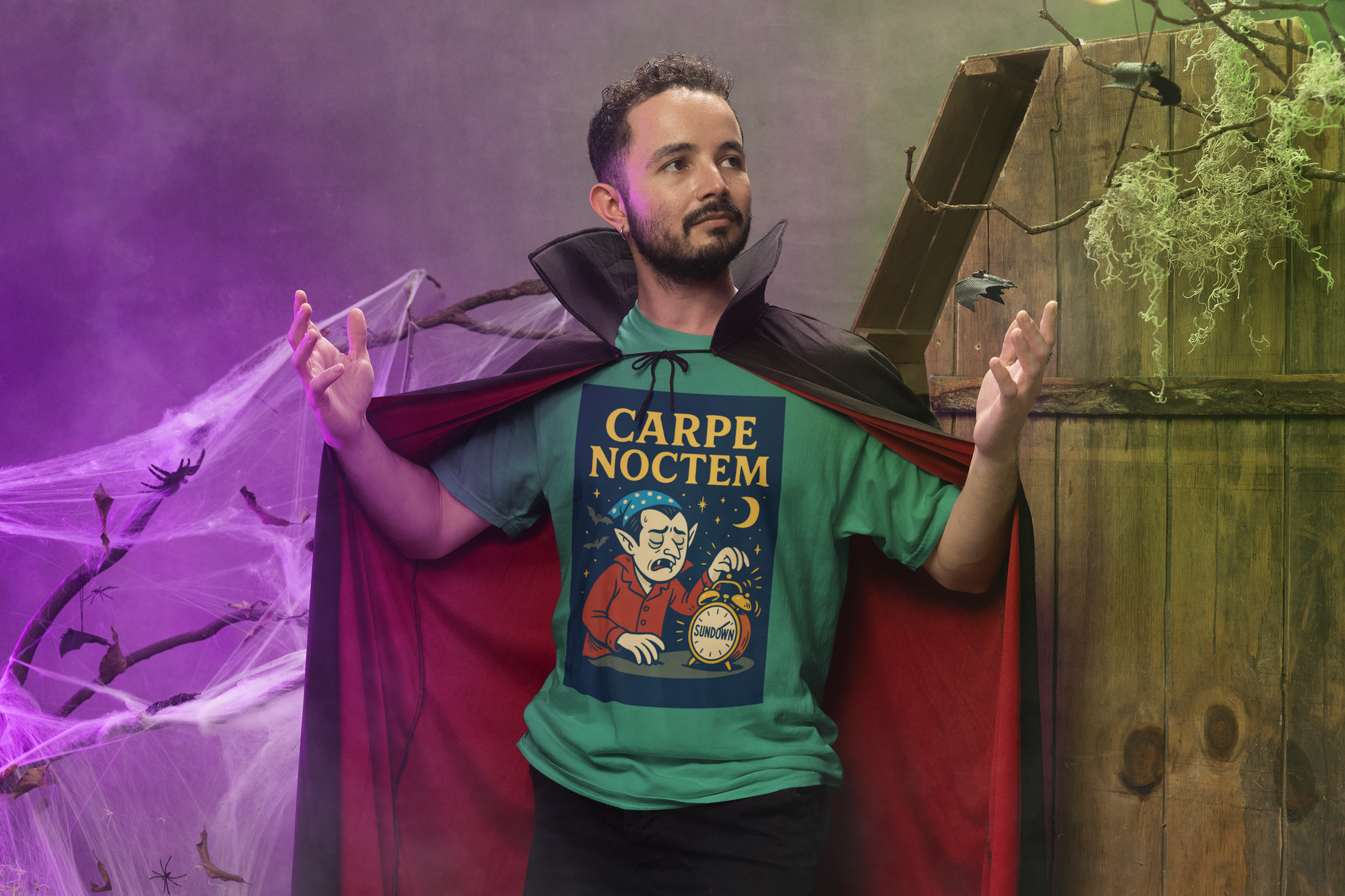 Man wearing a Dracula-themed t-shirt with 'Carpe Noctem' text and a vampire cape stands in a Halloween-themed setting.
