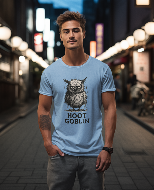 Man wearing a light blue t-shirt with an owl graphic and 'Hoot Goblin' text on a city street at night from WhimSpin.
