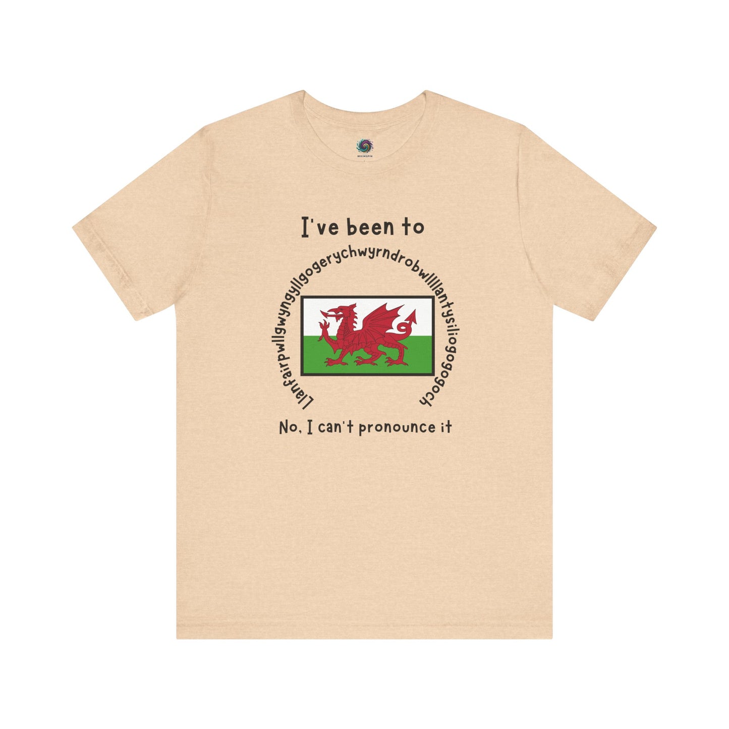 Llanfairpwllgwyngyllgogerychwyrndrobwllllantysiliogogogoch T-Shirt – Funny Wales Travel Merch in soft heather sand dune tone, with long place name and Welsh flag print.