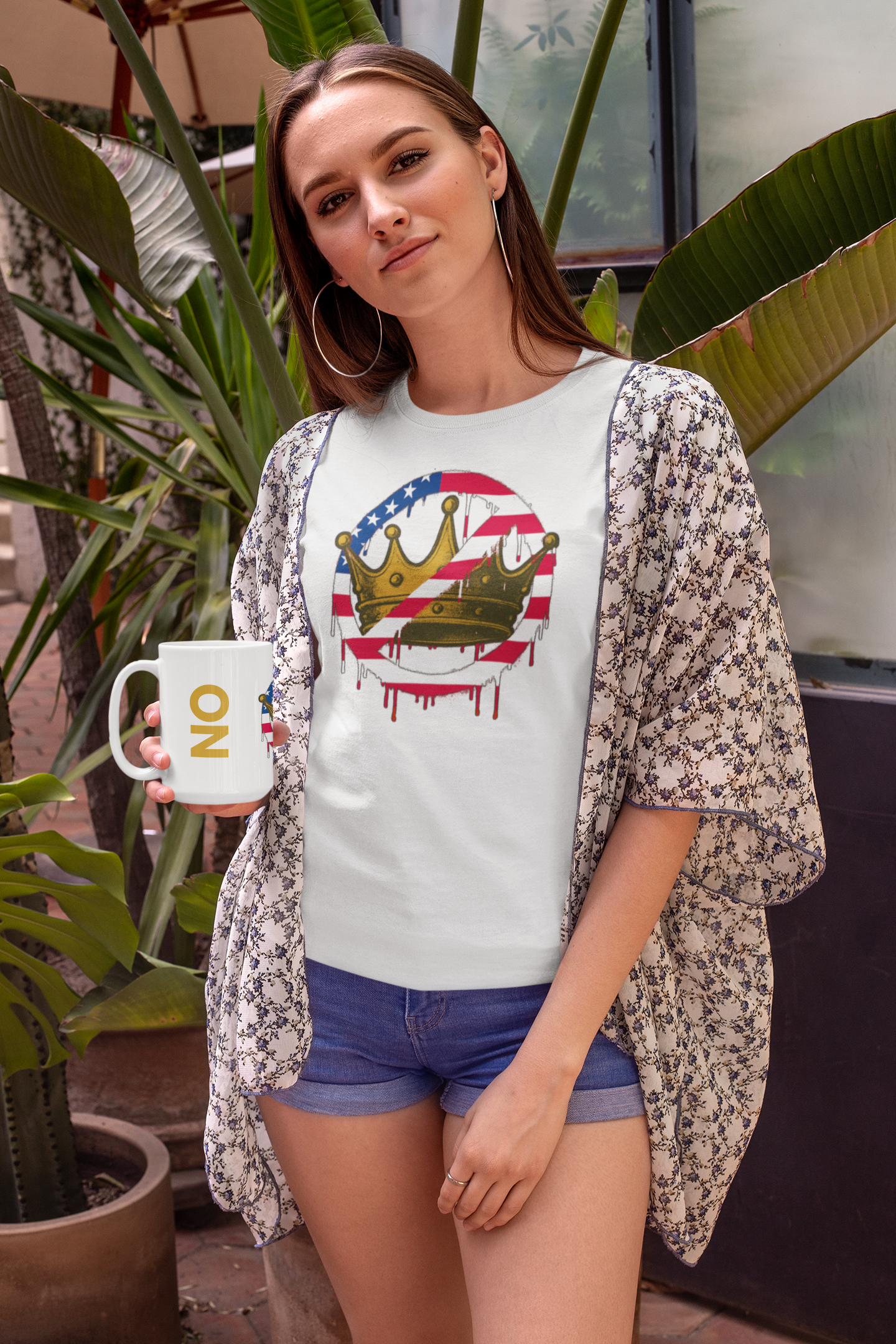 No Kings Mug – Anti-Monarchy Coffee Cup held by smiling woman in floral kimono and shorts with matching tee, tropical setting adds casual protest flair.