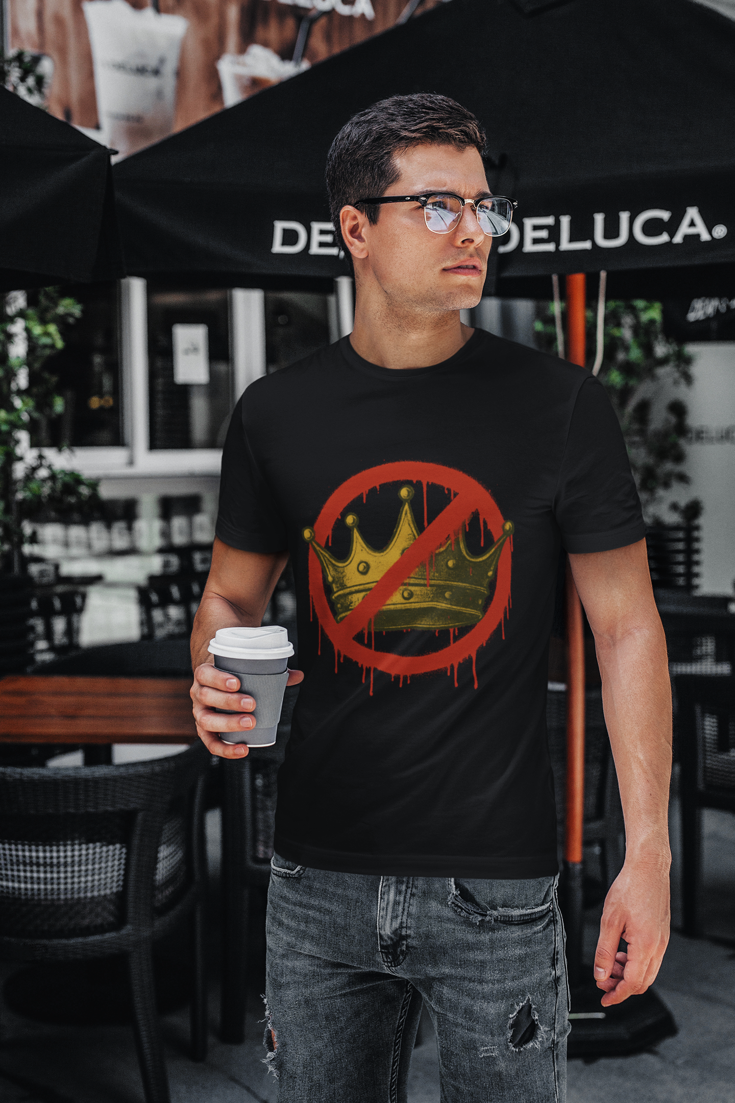 No Kings T-Shirt – Anti-Monarchy Protest Tee for Global Rebels worn by man in black shirt with coffee outside café, emphasizing bold graphic for street activism