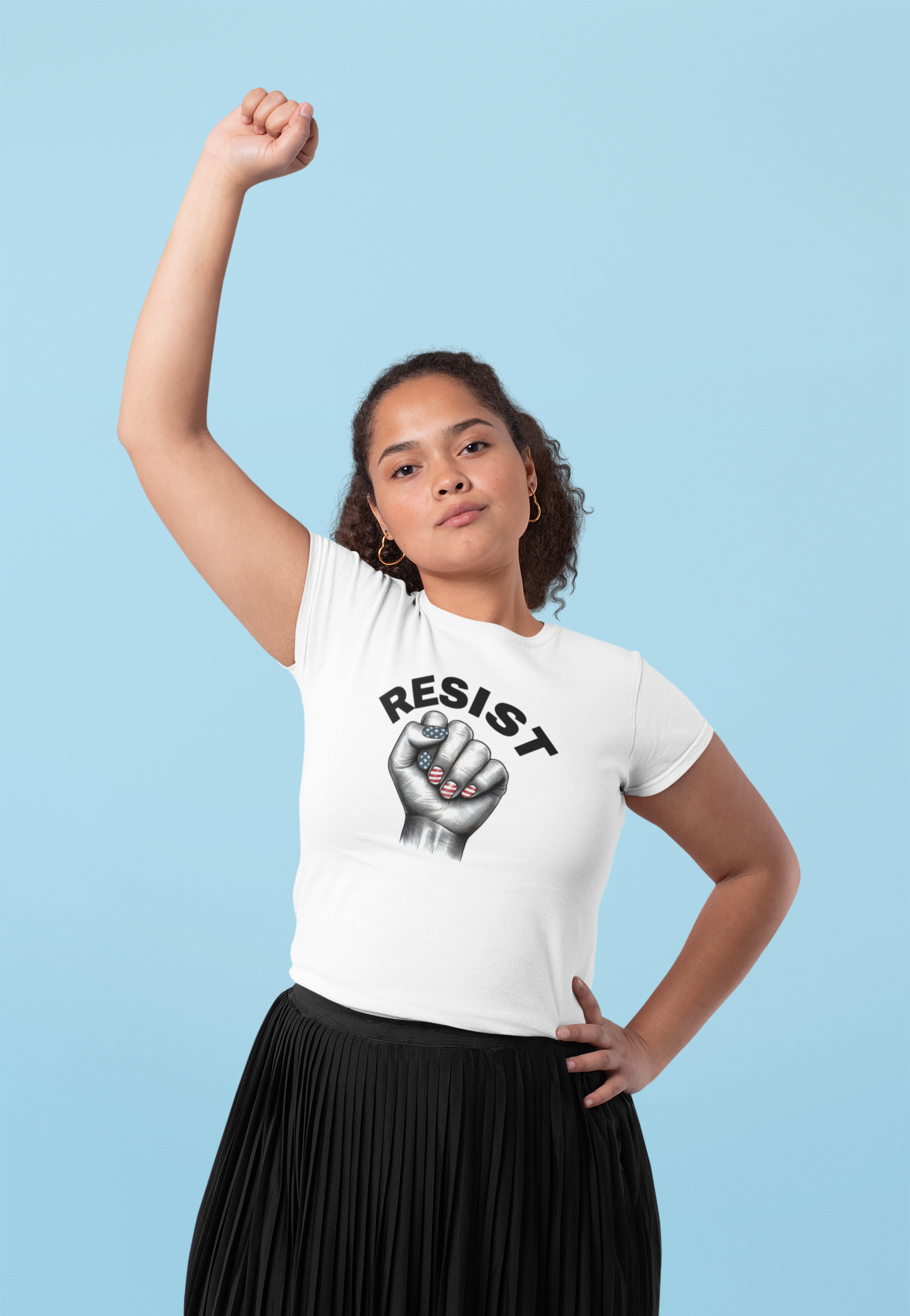Resist Feminist Power Fist Tee in white, shown on a woman raising her fist in solidarity, featuring USA flag nails and bold RESIST lettering.