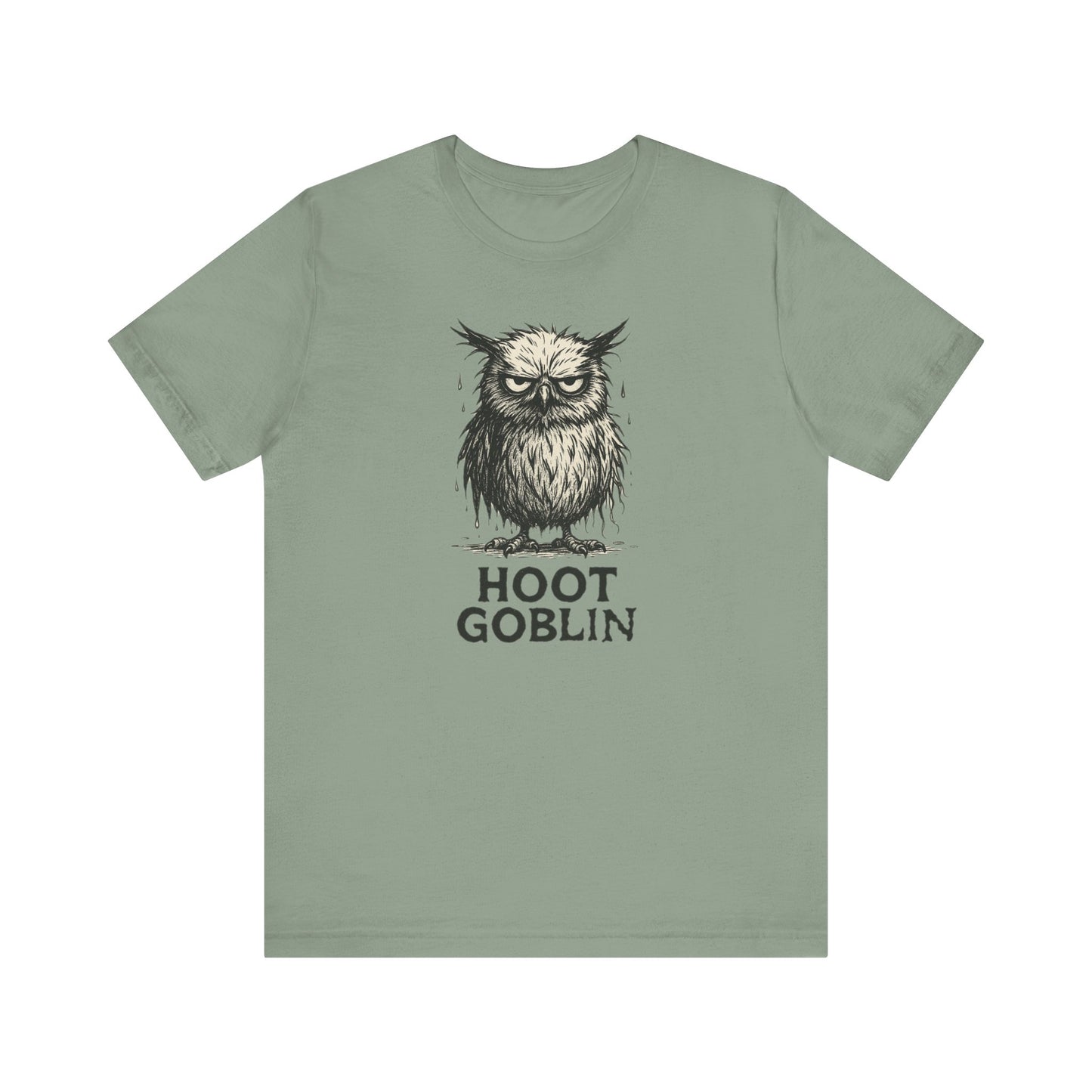 Sage green t-shirt with a sad owl design and 'Hoot Goblin' text on a white background