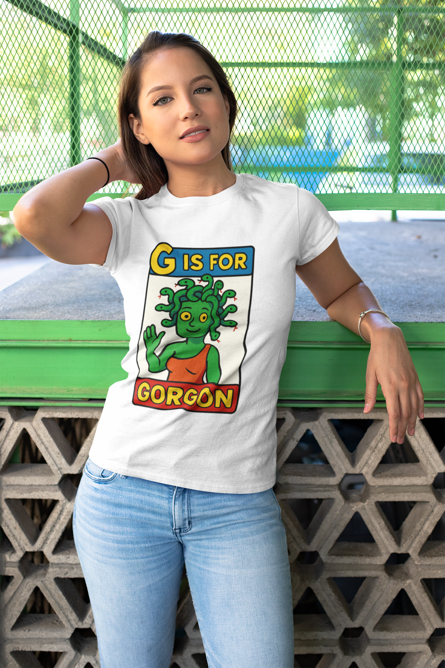 Lifestyle shot of woman in white G is for Gorgon T-Shirt, a whimsical halloween gorgon shirt with cartoon gorgon design.