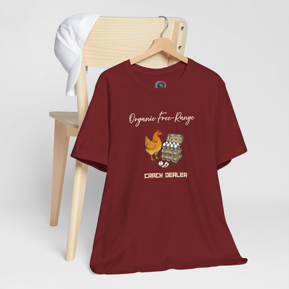 Maroon crew-neck T-shirt on hanger with chicken and egg “CRACK DEALER” graphic