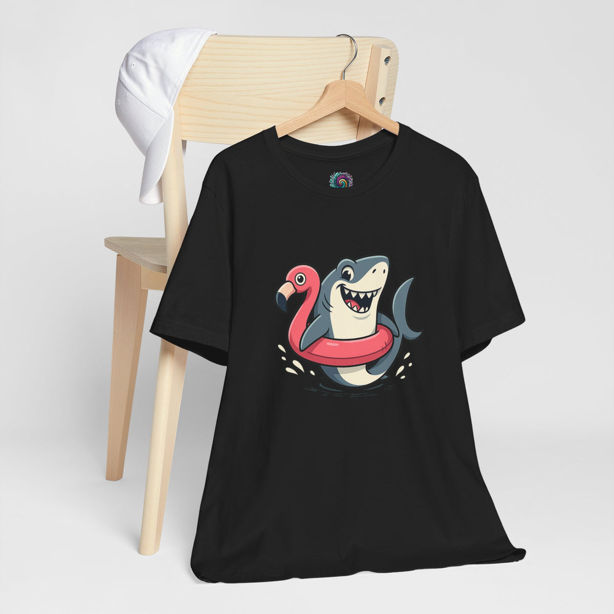 Black T-shirt on hanger with shark and flamingo floatie graphic, crew neck