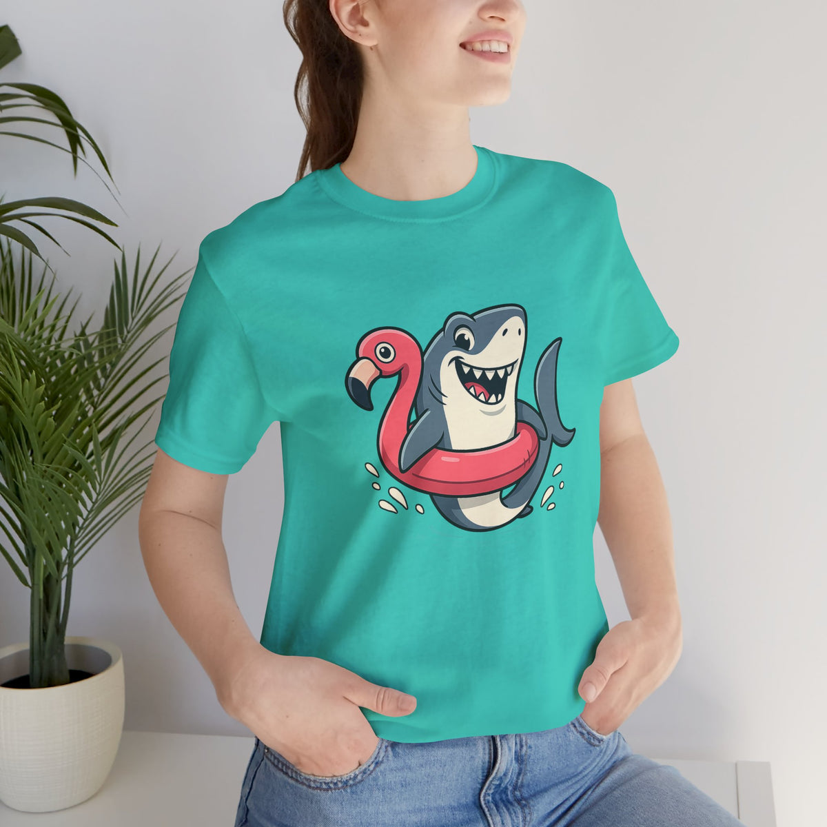 Teal crew-neck T-shirt with shark and flamingo floatie graphic on chest