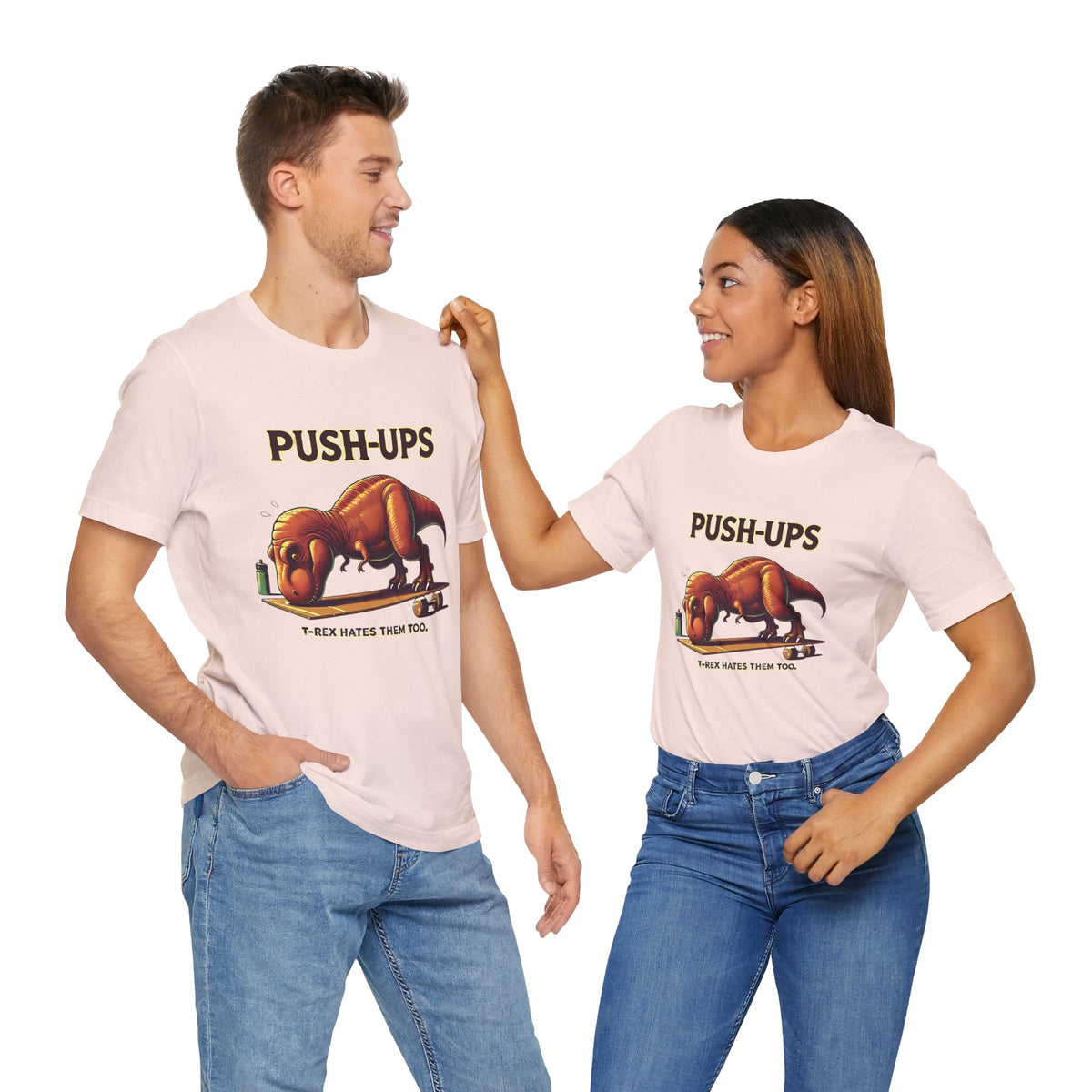 Pair of pink T-shirts with “PUSH-UPS” and T-rex workout dinosaur graphic on crew neck