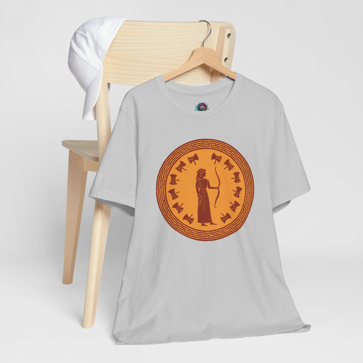 White crewneck T-shirt with circular bronze queen graphic, flat lay on hanger