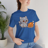 Blue t-shirt worn by model, featuring gray cat and orange turkey graphic