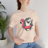 Cream crew-neck t-shirt with shark and flamingo float graphic, worn by woman