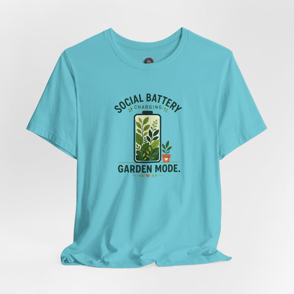 Blue graphic T-shirt flat lay with “SOCIAL BATTERY” and “GARDEN MODE” garden print