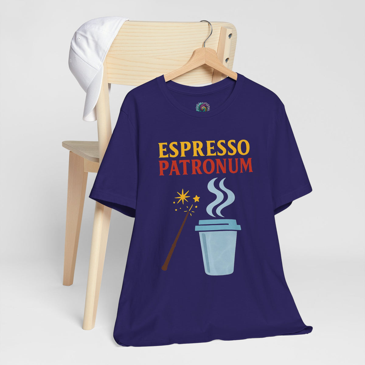 Navy “ESPRESSO PATRONUM” graphic t-shirt hanging on a wooden hanger