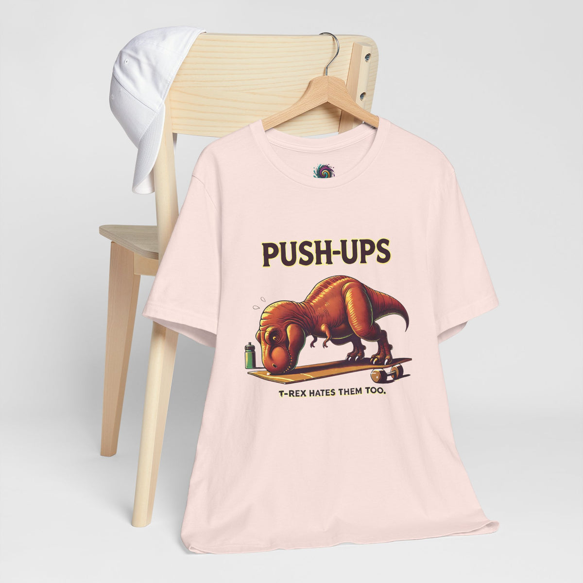 Pink crew-neck graphic T-shirt with “PUSH-UPS” and T-Rex push-up illustration