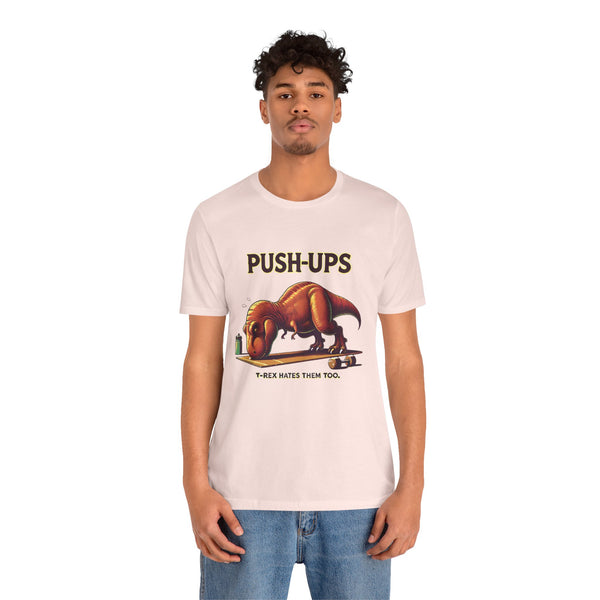 Pink crew-neck graphic T-shirt displaying “PUSH-UPS” and T-Rex push-up art