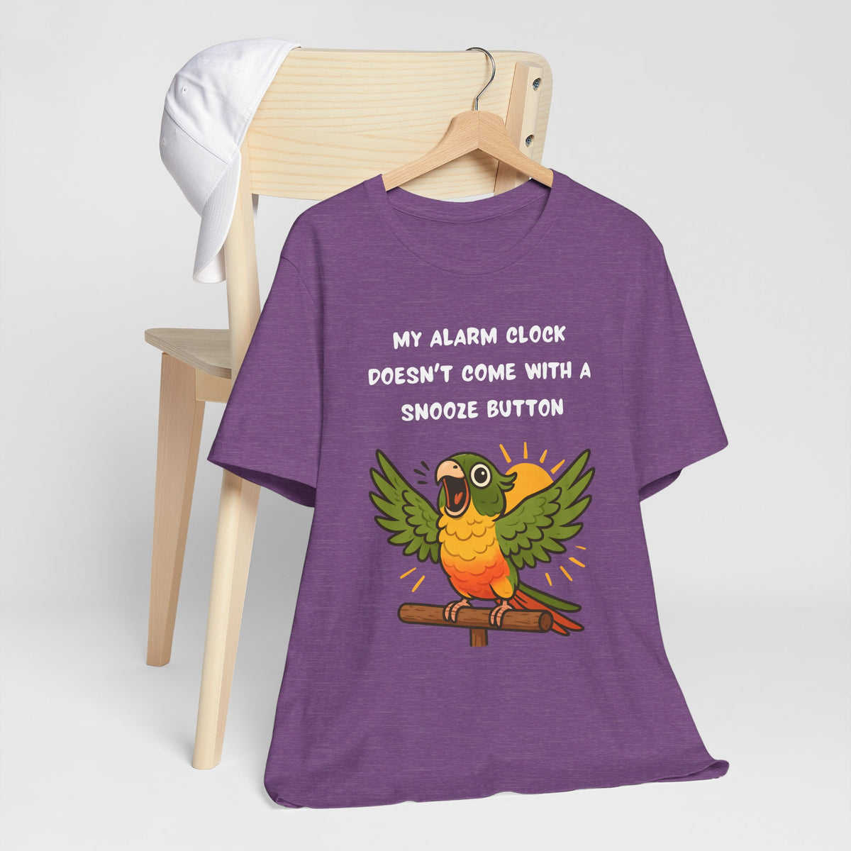 Purple crew-neck t-shirt with printed parrot graphic and “My alarm clock” message
