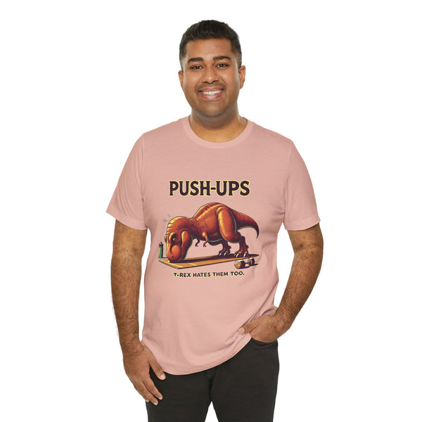 Pink graphic T-shirt with “PUSH-UPS” and T-rex workout dinosaur print, crew neck