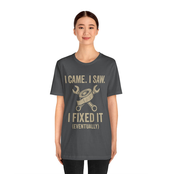 Charcoal short-sleeve tee with centered gold text slogan and crossed tools graphic