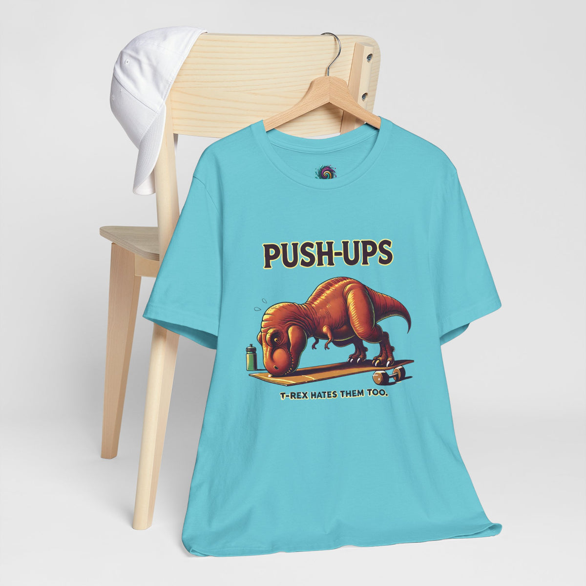 Turquoise T-shirt with T-rex 'Push-Ups' front graphic, on a wooden hanger