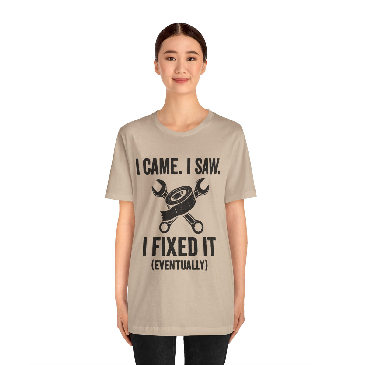 Beige crewneck tee on model featuring wrench and “I fixed it (eventually)” text