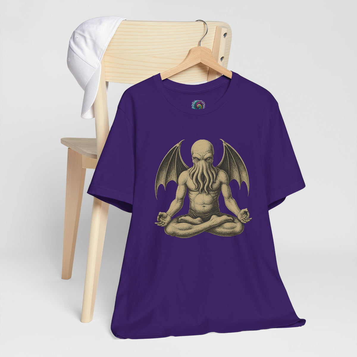 Team purple unisex crewneck T-shirt with meditating Cthulhu graphic, shown laid on a stand