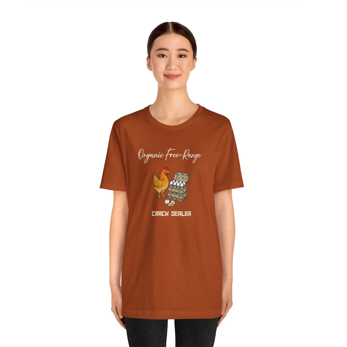 Rust orange crew-neck t-shirt worn by model; chicken and eggs graphic on chest
