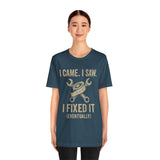 Teal short-sleeve T-shirt with crew neck and “I came, I saw, I fixed it (eventually)” text