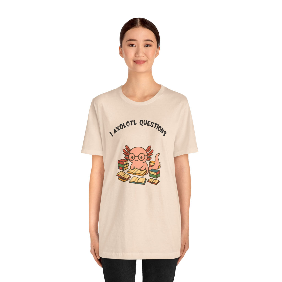 Soft cream t-shirt with axolotl reading illustration and “I axolotl questions” slogan