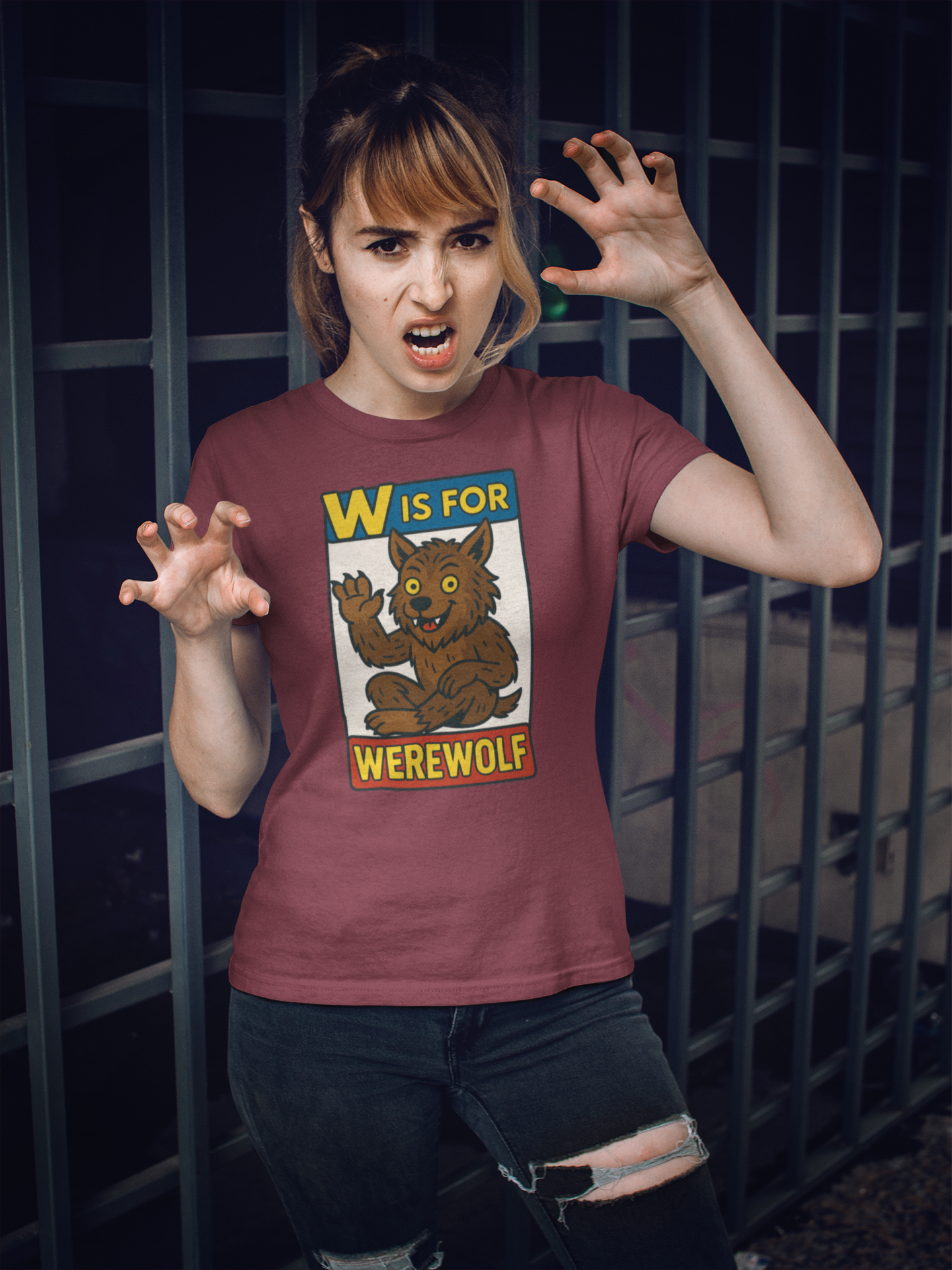 Person wearing a red t-shirt with a graphic of a werewolf and text 'W is for Werewolf' in front of a dark background.