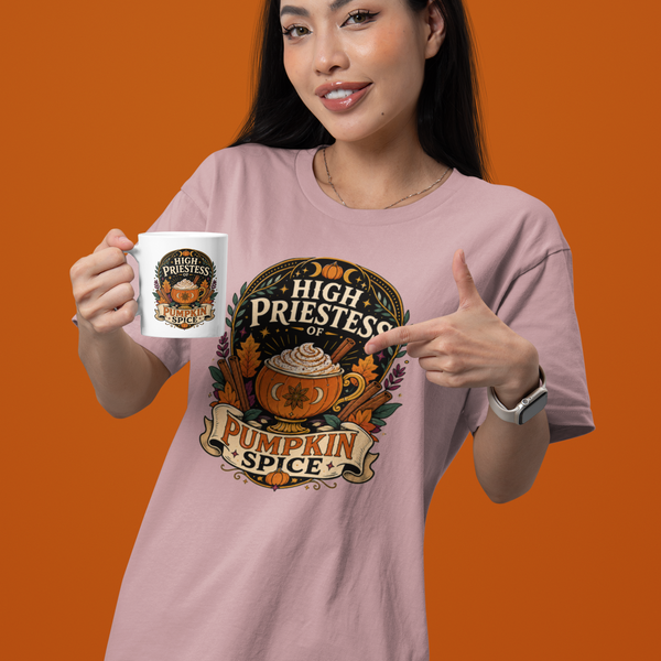 Lavender T-shirt with pumpkin spice emblem graphic, model pointing while holding a mug
