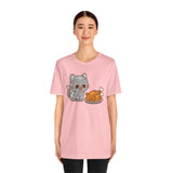 Pink crew-neck T-shirt with gray cat and brown roast graphic, short sleeves.