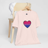 Soft pink Pride heart t-shirt with rainbow heart graphic on chest