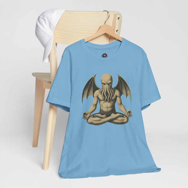 Light blue t-shirt on hanger with meditating monster graphic print on front