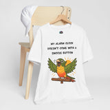 White graphic parrot alarm clock T-shirt on hanger, 'Snooze button' text and conure