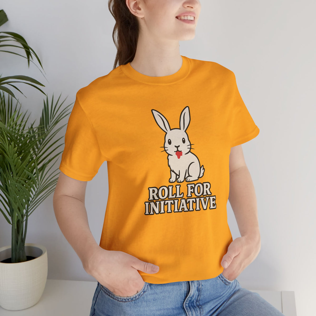 Orange crew-neck T-shirt worn by model, featuring bunny and "ROLL FOR INITIATIVE" print