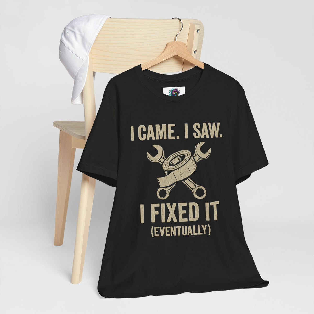Black crew-neck T-shirt on hanger with “I Came, I Saw I Fixed It (Eventually)” print