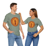 Two people wearing sage green crewneck T-shirts with orange circular Greek myth graphic