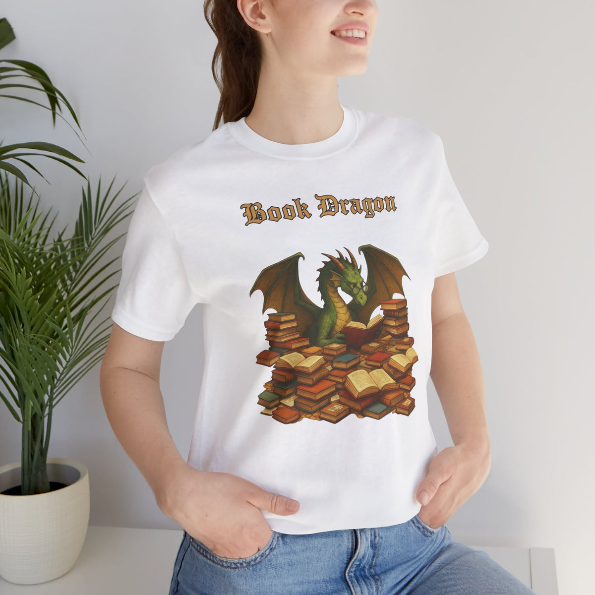 White crewneck t-shirt worn model, “Book Dragon” graphic with dragon over stacked books