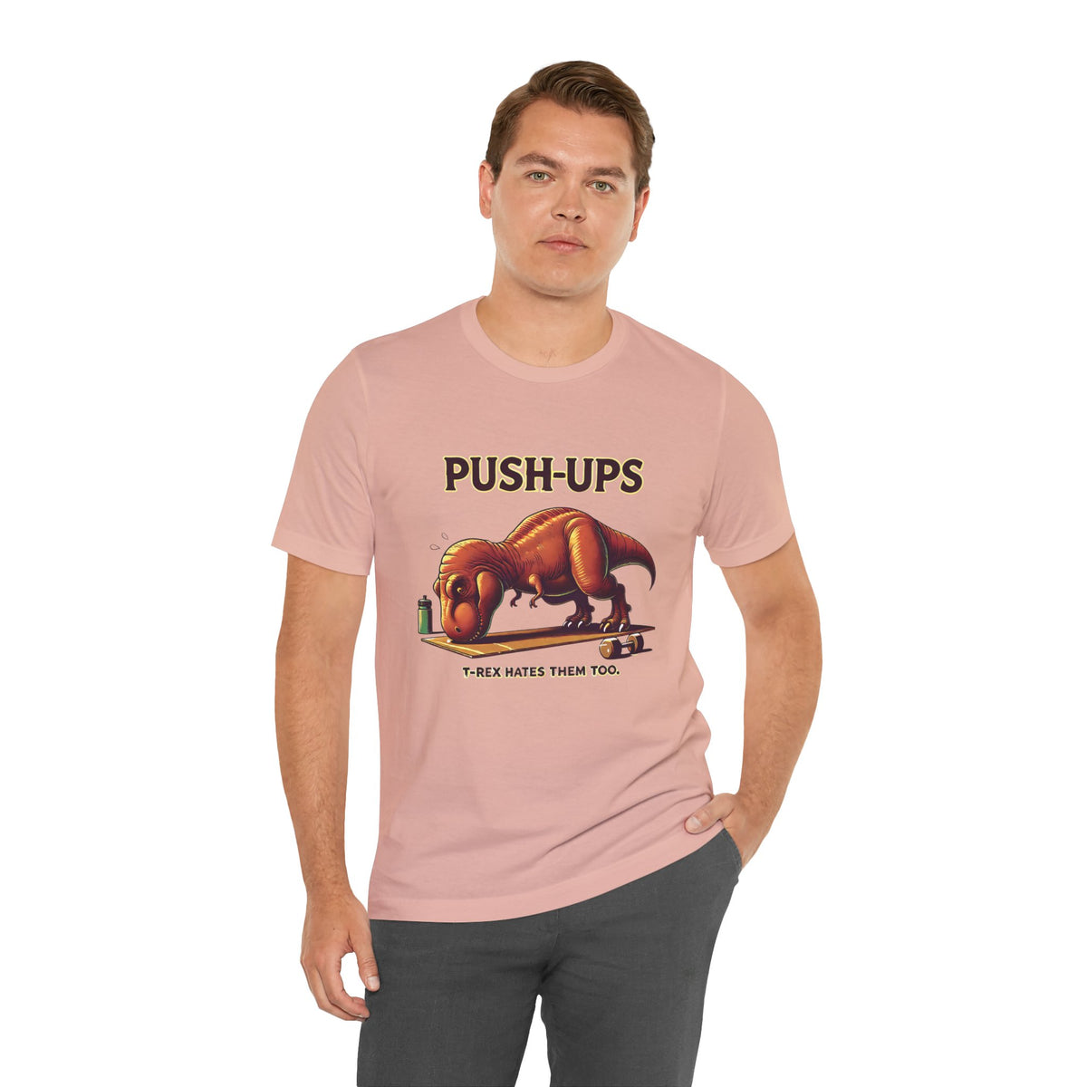 Pink crew-neck T-shirt with “PUSH-UPS” and T-rex workout dinosaur graphic, side pose