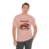 Pink crew-neck T-shirt with “PUSH-UPS” and T-rex workout dinosaur graphic, side pose