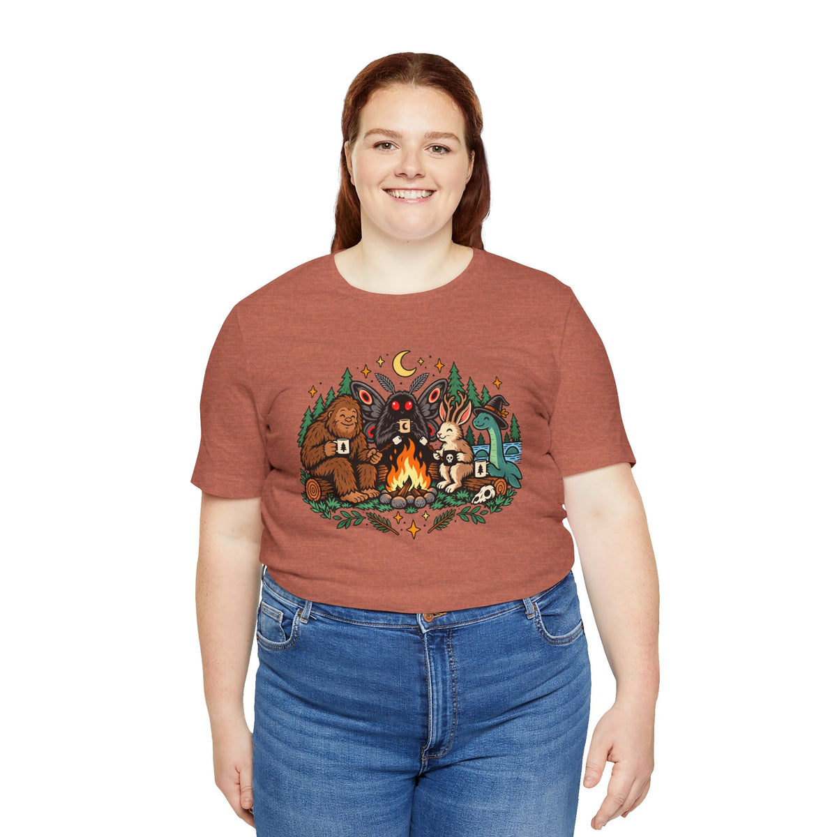 Rust-brown crewneck T-shirt with campfire cryptids illustration, worn by model