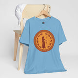 Heather blue T-shirt laid on a chair with orange circular Greek myth graphic
