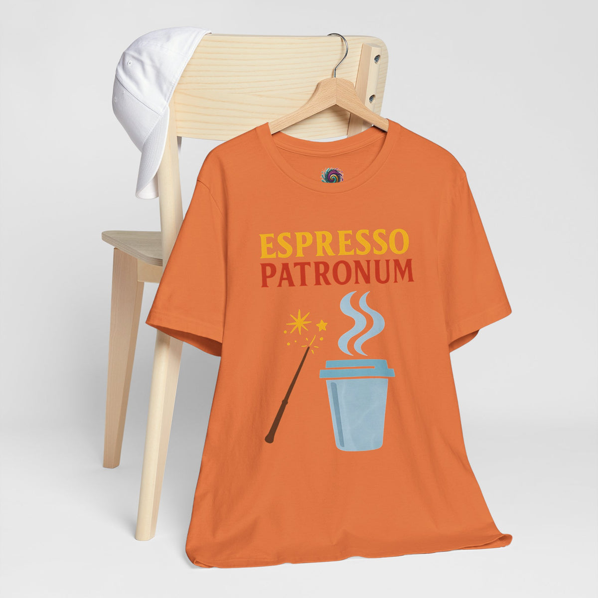Burnt orange t-shirt on hanger with “Espresso Patronum” coffee cup, steam, and wand graphic
