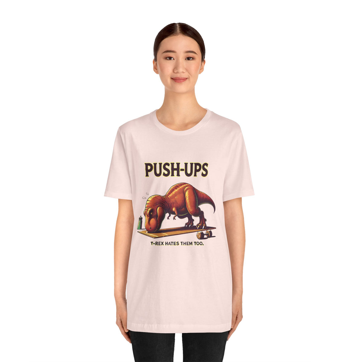 Pink crew-neck graphic tee with “PUSH-UPS” and T-Rex workout graphic