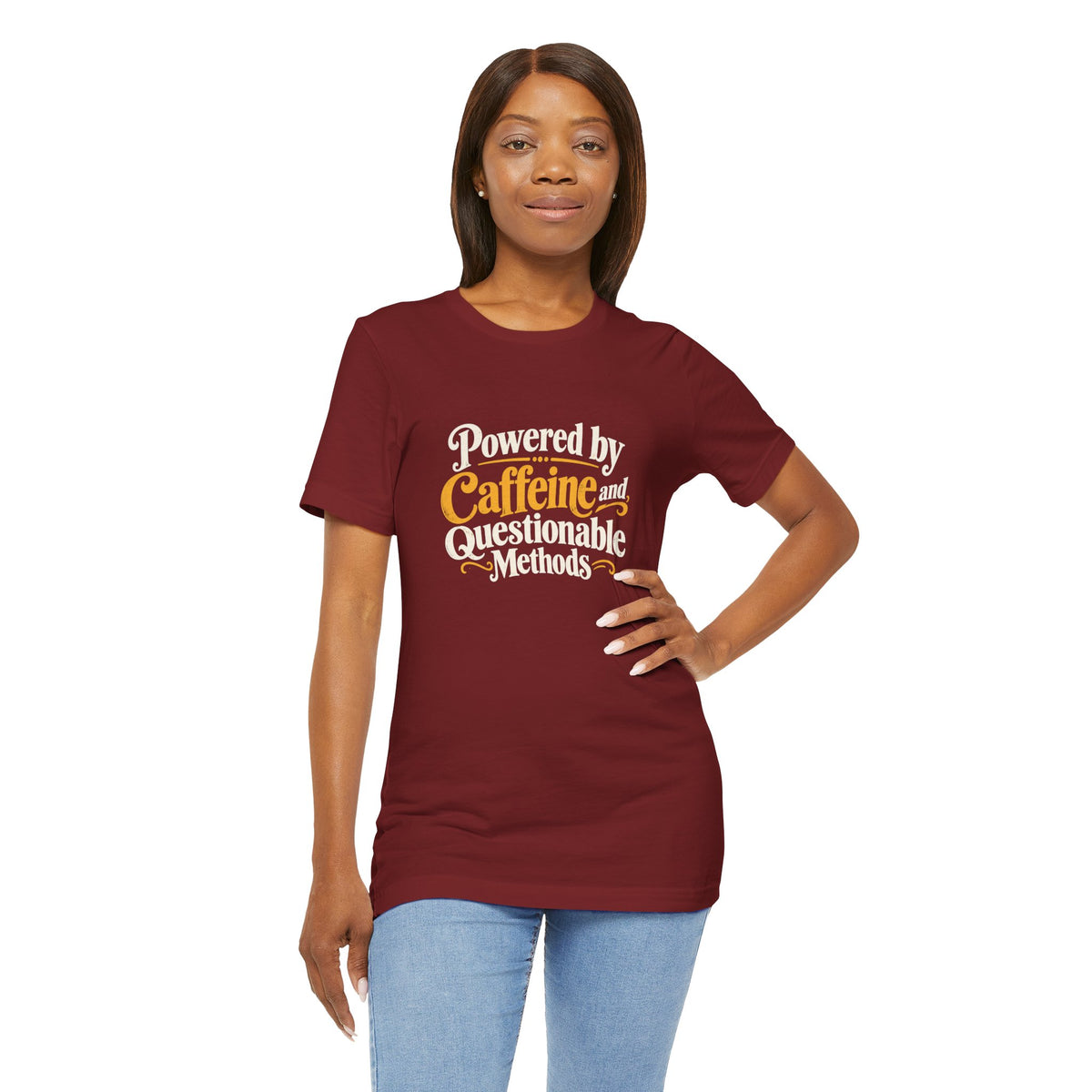 Maroon graphic T-shirt with "Powered by Caffeine and Questionable Methods" front print on model