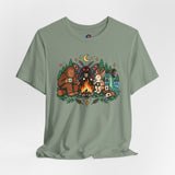 Sage green T-shirt with colorful campfire cryptid graphic centered on the chest