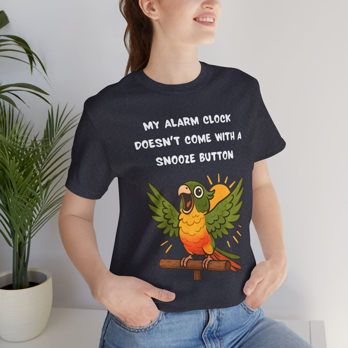 Dark heather T-shirt on model with parrot graphic and slogan 'My alarm clock...snooze button'