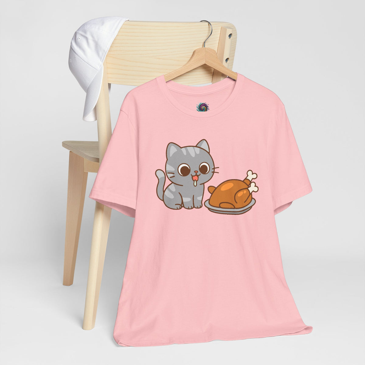 Pink crew-neck T-shirt with gray cat and brown roast graphic, short sleeves.