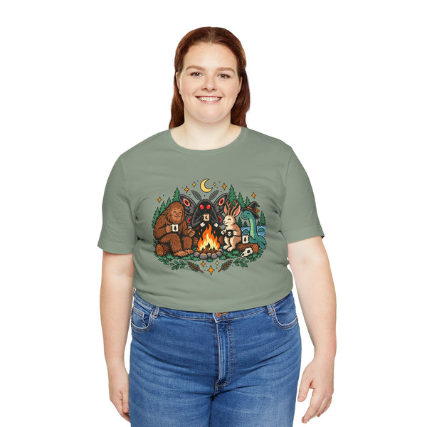 Sage green T-shirt with colorful campfire cryptid graphic on the front