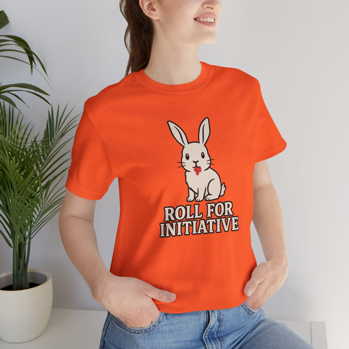 Orange crew-neck t-shirt featuring a white rabbit and “Roll for Initiative” text